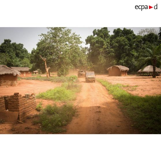 Une Peugeot P4 et un VAB sanitaire transportant le personnel du rôle 1 ou antenne médicale avancée du GTIA (groupement tactique interarmes) Turco, évoluent sur une route de campagne lors d'une reconnaissance du dispensaire du CRPR (centre régional polyvalent de recherche) de Bambari dans le cadre d'une AMP (aide médicale à la population).
