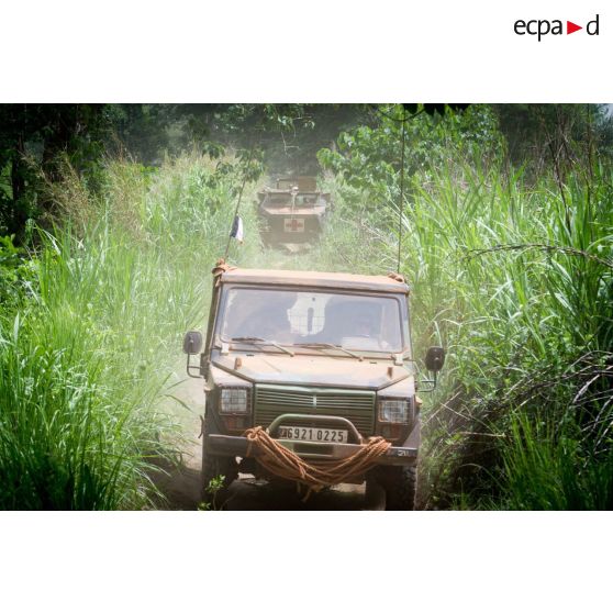 Une Peugeot P4 et un VAB sanitaire transportant le personnel du rôle 1 ou antenne médicale avancée du GTIA (groupement tactique interarmes) Turco, évoluent sur une route de campagne lors d'une reconnaissance du dispensaire du CRPR (centre régional polyvalent de recherche) de Bambari dans le cadre d'une AMP (aide médicale à la population).
