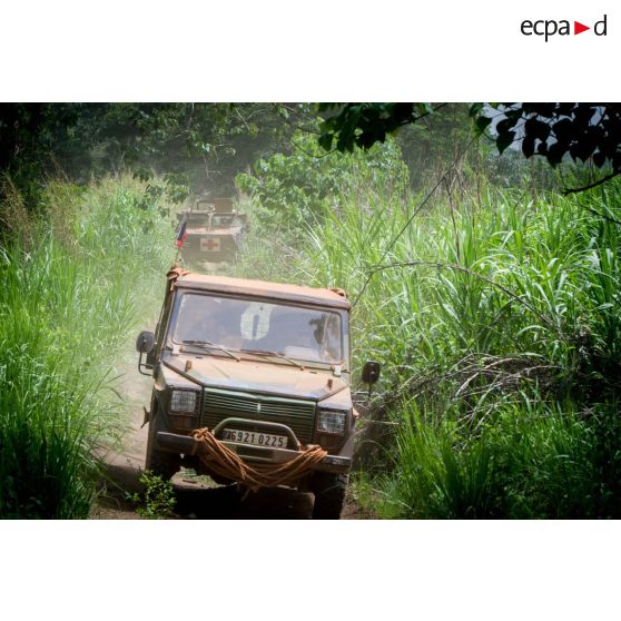 Une Peugeot P4 et un VAB sanitaire transportant le personnel du rôle 1 ou antenne médicale avancée du GTIA (groupement tactique interarmes) Turco, évoluent sur une route de campagne lors d'une reconnaissance du dispensaire du CRPR (centre régional polyvalent de recherche) de Bambari dans le cadre d'une AMP (aide médicale à la population).