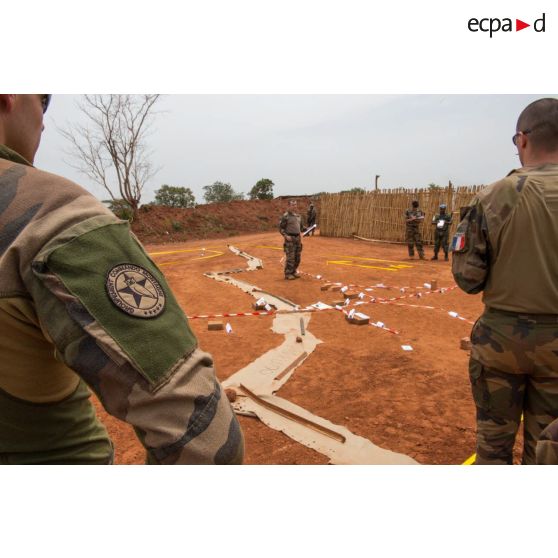 Un élément du GCM (groupement des commandos de montagne) du GTIA (groupement tactique interarmes) Vercors assiste à une répétition coordonnée sur caisse à sable des éléments de la force Sangaris et de la MINUSCA (mission multidimensionnelle intégrée des Nations Unies pour la stabilisation en Centrafrique) lors d'un briefing d'état-major au poste de commandement de la POD (plateforme opérationnelle défense) de Bambari.