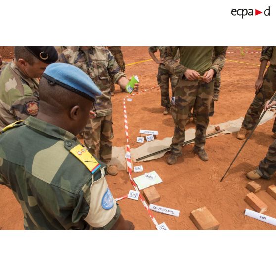 Le lieutenant-colonel Bitengalo, chef des forces armées démocratiques congolaises des casques bleus assiste conjointement avec le colonel Marc Espitalier, chef de corps du 1er RT et commandant le GTIA (groupement tactique interarmes) Turco, à une répétition coordonnée sur caisse à sable des éléments de la force Sangaris et de la MINUSCA (mission multidimensionnelle intégrée des Nations Unies pour la stabilisation en Centrafrique) lors d'un briefing d'état-major au poste de commandement de la POD (plateforme opérationnelle défense) de Bambari.