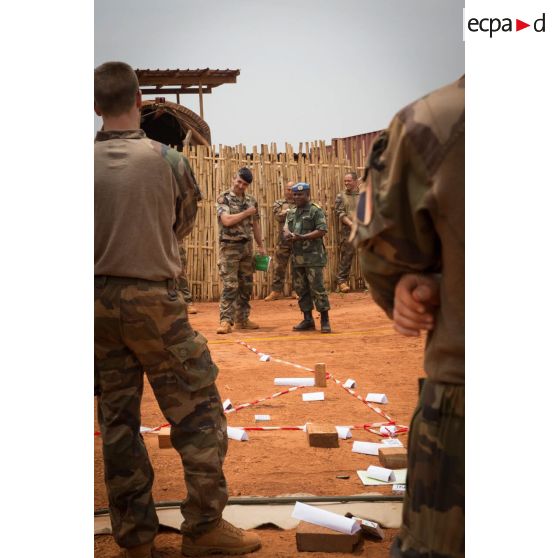 Le lieutenant-colonel Bitengalo, chef des forces armées démocratiques congolaises des casques bleus assiste conjointement avec le colonel Marc Espitalier, chef de corps du 1er RT et commandant le GTIA (groupement tactique interarmes) Turco, à une répétition coordonnée sur caisse à sable des éléments de la force Sangaris et de la MINUSCA (mission multidimensionnelle intégrée des Nations Unies pour la stabilisation en Centrafrique) lors d'un briefing d'état-major au poste de commandement de la POD (plateforme opérationnelle défense) de Bambari.