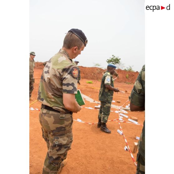 Le colonel Marc Espitalier, chef de corps du 1er RT et commandant le GTIA (groupement tactique interarmes) Turco, assiste conjointement avec le lieutenant-colonel Bitengalo, chef des forces armées démocratiques congolaises des casques bleus, à une répétition coordonnée sur caisse à sable des éléments de la force Sangaris et de la MINUSCA (mission multidimensionnelle intégrée des Nations Unies pour la stabilisation en Centrafrique) lors d'un briefing d'état-major au poste de commandement de la POD (plateforme opérationnelle défense) de Bambari.