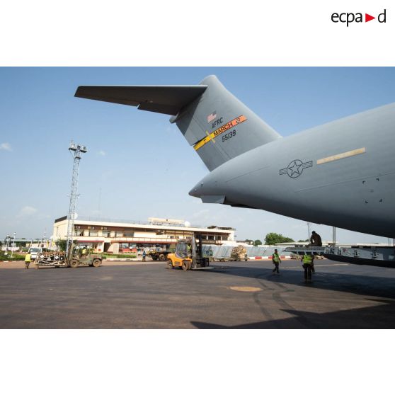 Des éléments du 1er RTP affecté au DéTIA (détachement de transit interarmées) procèdent au chargement de fret dans la soute d'un avion Douglas C-17 de l'US Air Force stationnant sur le tarmac de l'aéroport M'Poko de Bangui au moyen d'un chariot élévateur OMG Ergos 80 HYD, dans le cadre du désengagement progressif de la force Sangaris.