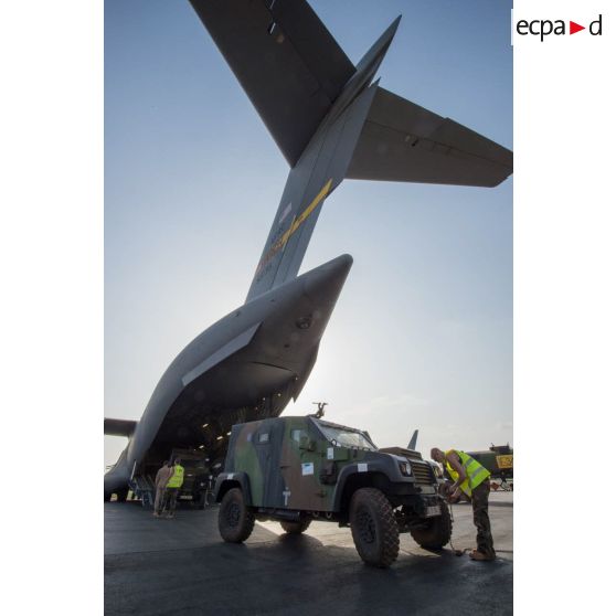 Des éléments du 1er RTP affecté au DéTIA (détachement de transit interarmées) procèdent au chargement de véhicules PVP (petit véhicule protégé) dans la soute d'un avion Douglas C-17 de l'US Air Force stationnant sur le tarmac de l'aéroport M'Poko de Bangui, dans le cadre du désengagement progressif de la force Sangaris.