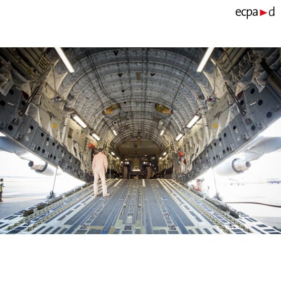Chargement de véhicules PVP (petit véhicule protégé) dans la soute d'un avion Douglas C-17 de l'US Air Force stationnant sur le tarmac de l'aéroport M'Poko de Bangui, dans le cadre du désengagement progressif de la force Sangaris.