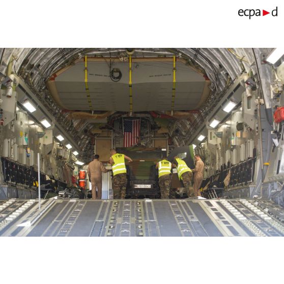 Aidés par le personnel navigant de l'US Air Force, les éléments du 1er RTP affecté au DéTIA (détachement de transit interarmées) procèdent au chargement de véhicules PVP (petit véhicule protégé) dans la soute d'un avion Douglas C-17 stationnant sur le tarmac de l'aéroport M'Poko de Bangui, dans le cadre du désengagement progressif de la force Sangaris.