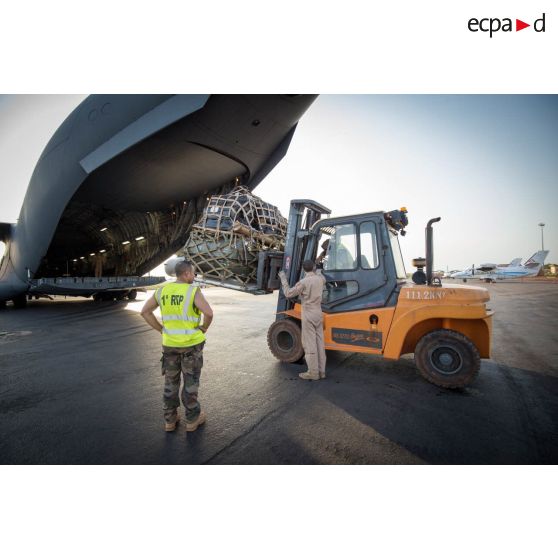 Aidés par le personnel navigant de l'US AIr Force, les éléments du 1er RTP affecté au DéTIA (détachement de transit interarmées) procèdent au chargement de fret dans la soute d'un avion Douglas C-17 stationnant sur le tarmac de l'aéroport M'Poko de Bangui au moyen d'un chariot élévateur OMG Ergos 80 HYD, dans le cadre du désengagement progressif de la force Sangaris.