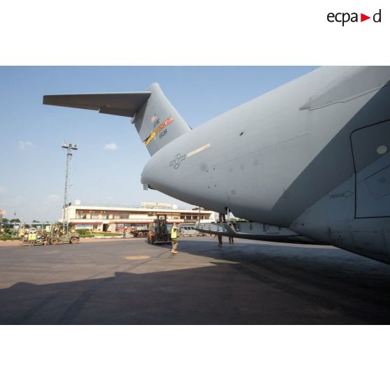 Des éléments du 1er RTP affecté au DéTIA (détachement de transit interarmées) procèdent au chargement de fret dans la soute d'un avion Douglas C-17 de l'US Air Force stationnant sur le tarmac de l'aéroport M'Poko de Bangui au moyen d'un chariot élévateur OMG Ergos 80 HYD, dans le cadre du désengagement progressif de la force Sangaris.