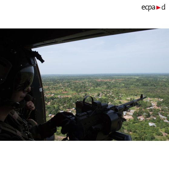 Soldat du 3e RHC du SGAM (sous-groupement aéromobile) Barracuda servant une mitrailleuse polyvalente FN MAG 58 de 7,62 mm depuis le hublot latéral d'un hélicoptère Puma SA-330 survolant une zone habitée autour du PK 26 (point kilométrique), dans le secteur au Nord de Bangui.