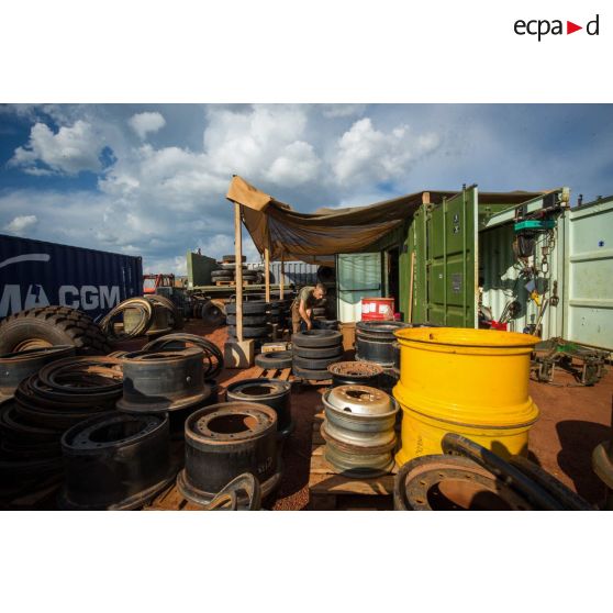 Un mécanicien effectue une réparation sur la roue d'un véhicule, à l'atelier de réparation mécanique du train de combat du camp de M'Poko de Bangui.