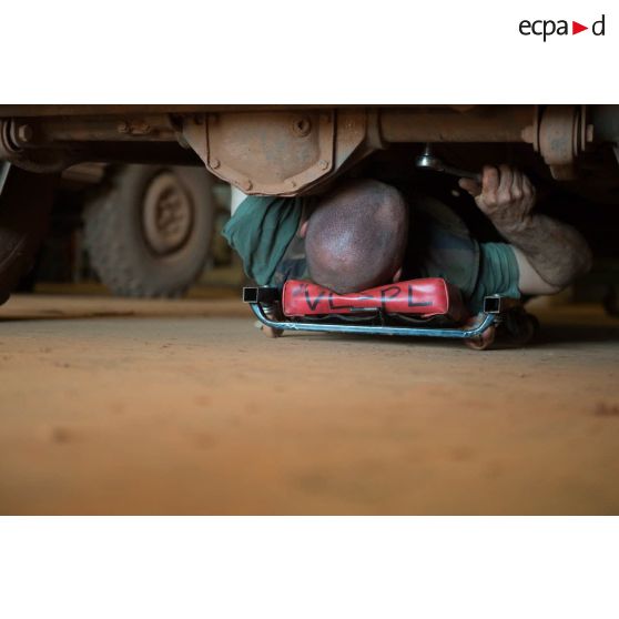 Un mécanicien effectue une réparation sur un véhicule, à l'atelier de réparation mécanique du train de combat du camp de M'Poko de Bangui.