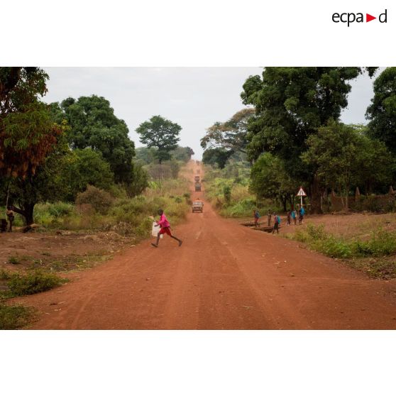Des écoliers traversent la route empruntée par le convoi du DETLOG (détachement logistique) lors du retour d'une mission de ravitaillement de la POD (plateforme opérationnelle défense) de Bambari vers Bangui.