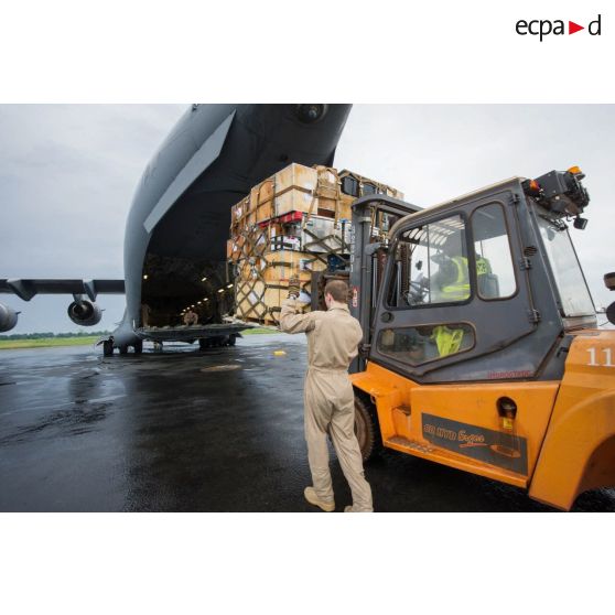 Chargement de fret dans la soute d'un avion Douglas C-17 de l'US Air Force en stationnement sur le tarmac de l'aéroport de Bangui-M'Poko au moyen d'un chariot élévateur Ergos 80 HYD, dans le cadre du désengagement de matériel par les soldats du 1er RTP du DéTIA (détachement de transit interarmées).