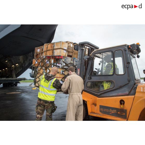 Chargement de fret dans la soute d'un avion Douglas C-17 de l'US Air Force en stationnement sur le tarmac de l'aéroport de Bangui-M'Poko au moyen d'un chariot élévateur Ergos 80 HYD, dans le cadre du désengagement de matériel par les soldats du 1er RTP du DéTIA (détachement de transit interarmées).