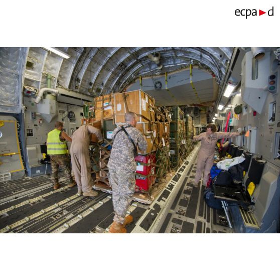 Aidés par les aviateurs américains de la 452e Air Mobility Wing, les soldats du 1er RTP du DéTIA (détachement de transit interarmées) chargent du fret dans la soute d'un avion Douglas C-17 de l'US Air Force, dans le cadre du désengagement de matériel depuis l'aéroport de Bangui-M'Poko.