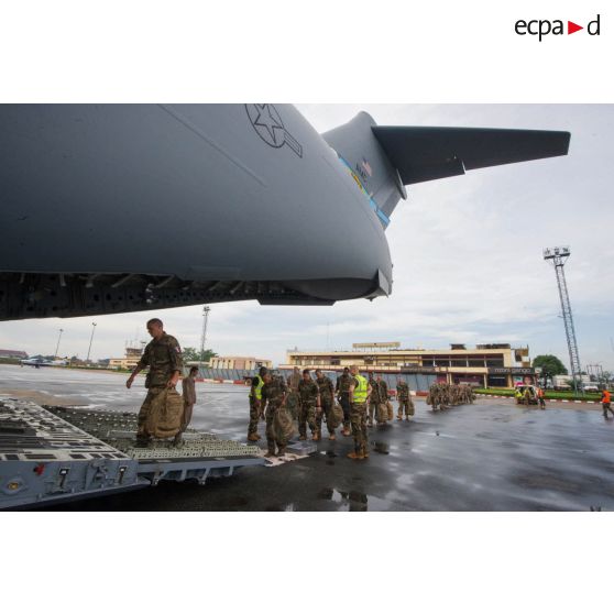 Encadrés par les soldats du 1er RTP du DéTIA (détachement de transit interarmées), les soldats de la force Sangaris embarquent à bord d'un avion Douglas C-17 de l'US Air Force, dans le cadre d'un désengagement depuis l'aéroport de Bangui-M'Poko.