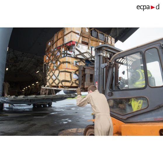 Chargement de fret dans la soute d'un avion Douglas C-17 de l'US Air Force en stationnement sur le tarmac de l'aéroport de Bangui-M'Poko au moyen d'un chariot élévateur Ergos 80 HYD, dans le cadre du désengagement de matériel par les soldats du 1er RTP du DéTIA (détachement de transit interarmées).