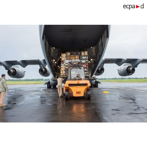 Chargement de fret dans la soute d'un avion Douglas C-17 de l'US Air Force en stationnement sur le tarmac de l'aéroport de Bangui-M'Poko au moyen d'un chariot élévateur Ergos 80 HYD, dans le cadre du désengagement de matériel par les soldats du 1er RTP du DéTIA (détachement de transit interarmées).