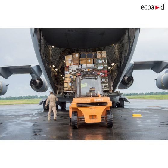Chargement de fret dans la soute d'un avion Douglas C-17 de l'US Air Force en stationnement sur le tarmac de l'aéroport de Bangui-M'Poko au moyen d'un chariot élévateur Ergos 80 HYD, dans le cadre du désengagement de matériel par les soldats du 1er RTP du DéTIA (détachement de transit interarmées).