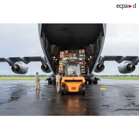 Chargement de fret dans la soute d'un avion Douglas C-17 de l'US Air Force en stationnement sur le tarmac de l'aéroport de Bangui-M'Poko au moyen d'un chariot élévateur Ergos 80 HYD, dans le cadre du désengagement de matériel par les soldats du 1er RTP du DéTIA (détachement de transit interarmées).