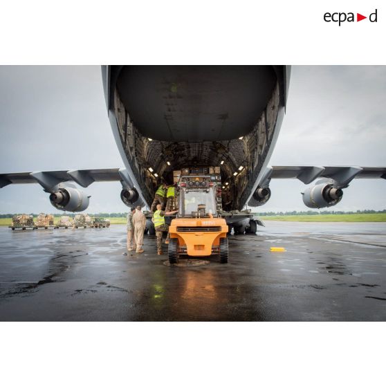 Chargement de fret dans la soute d'un avion Douglas C-17 de l'US Air Force en stationnement sur le tarmac de l'aéroport de Bangui-M'Poko au moyen d'un chariot élévateur Ergos 80 HYD, dans le cadre du désengagement de matériel par les soldats du 1er RTP du DéTIA (détachement de transit interarmées).