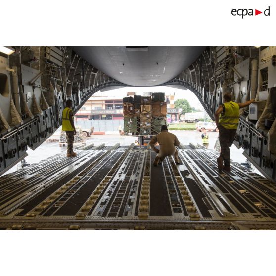 Aidés par les aviateurs américains de la 452e Air Mobility Wing, les soldats du 1er RTP du DéTIA (détachement de transit interarmées) chargent du fret dans la soute d'un avion Douglas C-17 de l'US Air Force, dans le cadre du désengagement de matériel depuis l'aéroport de Bangui-M'Poko.