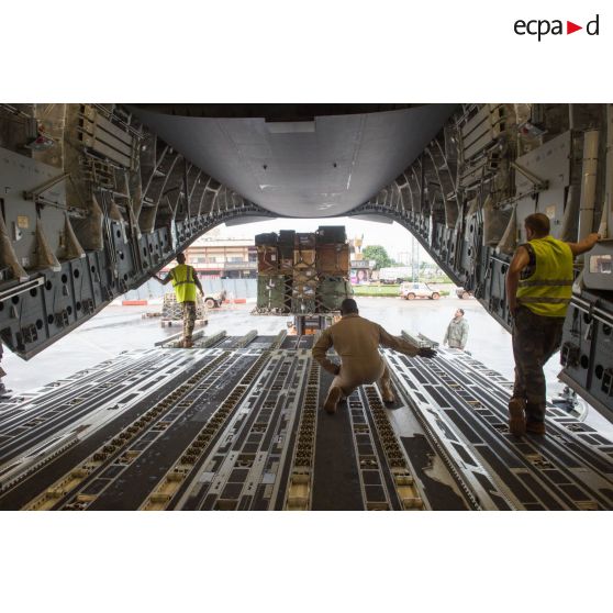 Aidés par les aviateurs américains de la 452e Air Mobility Wing, les soldats du 1er RTP du DéTIA (détachement de transit interarmées) chargent du fret dans la soute d'un avion Douglas C-17 de l'US Air Force, dans le cadre du désengagement de matériel depuis l'aéroport de Bangui-M'Poko.