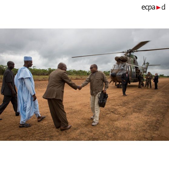 Monsieur Jean-Jacques Démafouth, conseiller auprès de la Présidence de la République centrafricaine, est accueilli par les autorités locales, lors de son arrivée avec la délégation franco-centrafricaine par hélicoptère Puma SA-330 sur la piste de l'aérodrome de Boda pour une réunion de sécurité.