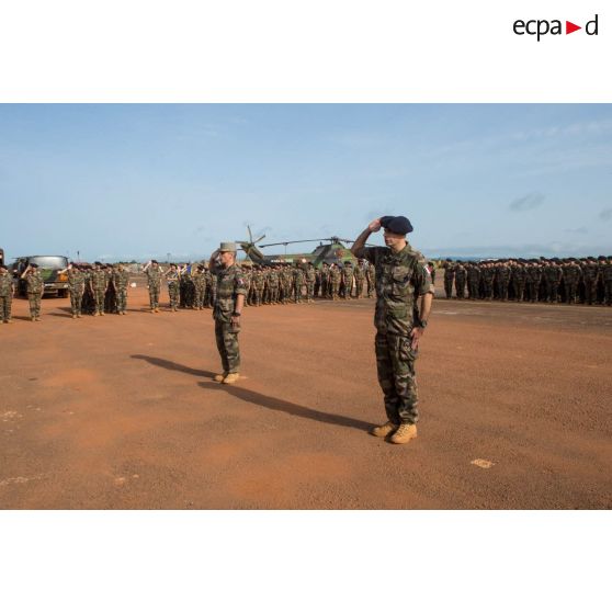 Le général de brigade Pierre Gillet, commandant la force Sangaris et le colonel Lionel Catar, chef de corps du 7e BCA et commandant le GTIA (groupement tactique interarmes) Vercors, saluent les couleurs dans le cadre d'une cérémonie de fin de mission sur le camp M'Poko de Bangui.
