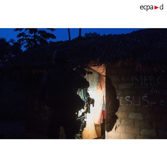 Fouille d'une habitation par un tirailleur du 1er RT du GTIA (groupement tactique interarmes) Vercors, lors d'une patrouille dans le village de Liby, dans le secteur de Damara, en appui aux casques bleus burundais de la MINUSCA (mission multidimensionnelle intégrée des Nations Unies pour la stabilisation en Centrafrique).