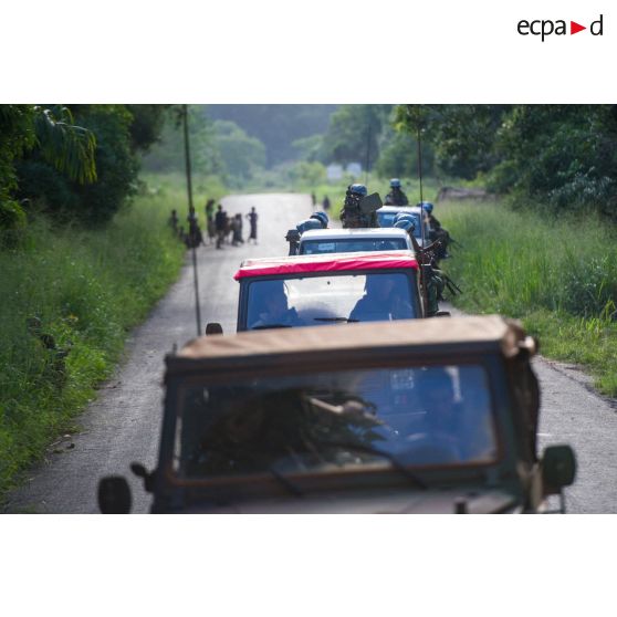 Les casques bleus burundais de la MINUSCA (mission multidimensionnelle intégrée des Nations Unies pour la stabilisation en Centrafrique) évoluent sur une route de campagne, appuyés par les troupes du 1er RT du GTIA (groupement tactique interarmes) Vercors montées à bord de divers véhicules dont deux Peugeot P4, lors d'une patrouille dans le secteur de Damara.