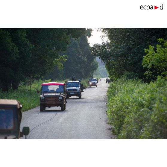 Les casques bleus burundais de la MINUSCA (mission multidimensionnelle intégrée des Nations Unies pour la stabilisation en Centrafrique) évoluent sur une route de campagne, appuyés par les troupes du 1er RT du GTIA (groupement tactique interarmes) Vercors montées à bord de divers véhicules dont deux Peugeot P4, lors d'une patrouille dans le secteur de Damara.