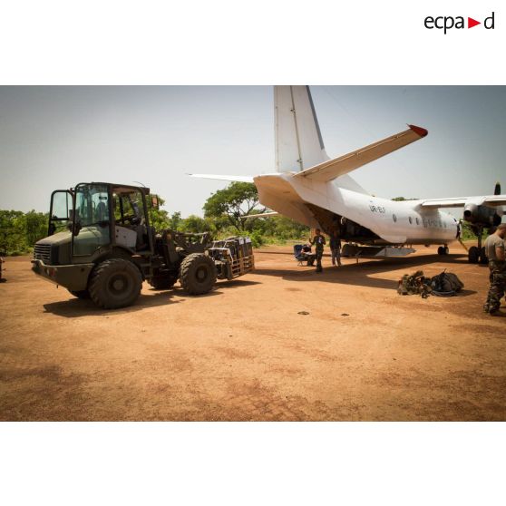 Les logisticiens du DéTIA (détachement de transit interarmées) chargent du matériel dans la soute d'un Antonov An-26 UR-ELF affrété par l'ONU, à l'aide d'une tractopelle Terex TL210, dans le cadre de la réduction de la BOA (base opérationnelle avancée) de N'Délé, à 658 Km au Nord-est de Bangui.