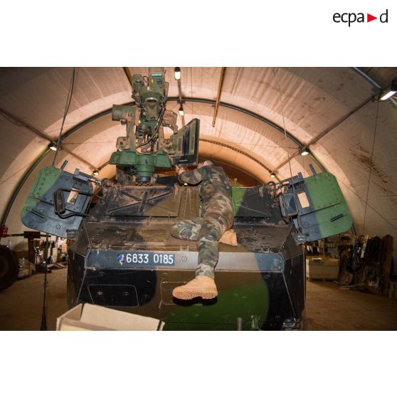 Maintenance mécanique de la tourelle M151 Protector d'un VAB TOP (tourelle téléopérée) par un tirailleur du 1er RT du GTIA (groupement tactique interarmes) Turco, au train de combat du camp M'Poko de Bangui.
