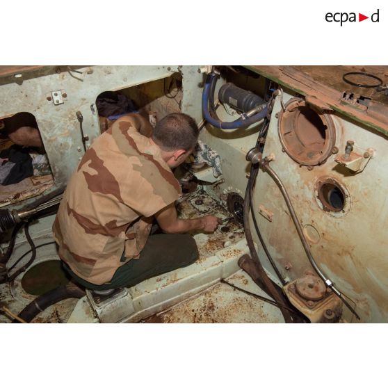 Maintenance mécanique dans l'habitacle d'un VAB par un tirailleur du 1er RT du GTIA (groupement tactique interarmes) Turco, au train de combat du camp M'Poko de Bangui.