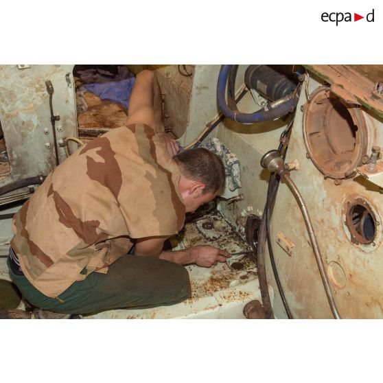 Maintenance mécanique dans l'habitacle d'un VAB par un tirailleur du 1er RT du GTIA (groupement tactique interarmes) Turco, au train de combat du camp M'Poko de Bangui.