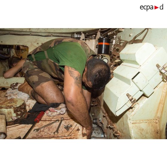 Maintenance mécanique dans l'habitacle d'un VAB par un tirailleur du 1er RT du GTIA (groupement tactique interarmes) Turco, au train de combat du camp M'Poko de Bangui.