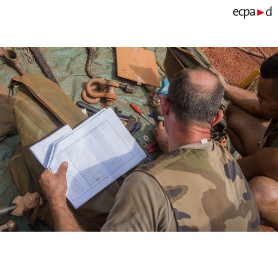 Deux tirailleurs du 1er RT du GTIA (groupement tactique interarmes) Turco procèdent à l'inventaire des outils de réparation dans le cadre d'un reconditionnement de matériel au train de combat du camp M'Poko de Bangui.
