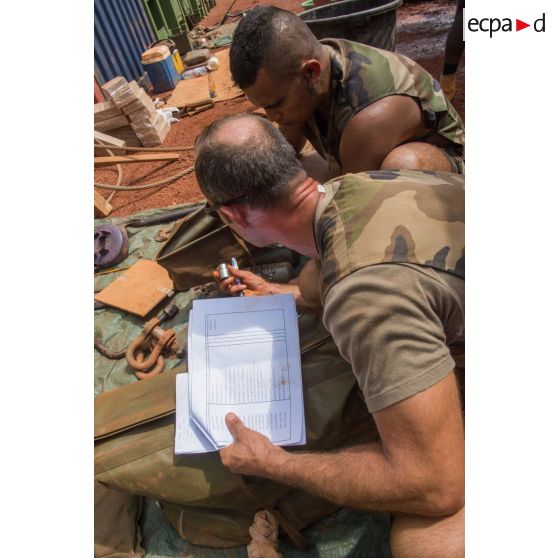 Deux tirailleurs du 1er RT du GTIA (groupement tactique interarmes) Turco procèdent à l'inventaire des outils de réparation dans le cadre d'un reconditionnement de matériel au train de combat du camp M'Poko de Bangui.