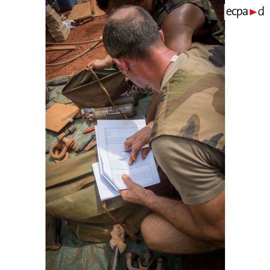 Deux tirailleurs du 1er RT du GTIA (groupement tactique interarmes) Turco procèdent à l'inventaire des outils de réparation dans le cadre d'un reconditionnement de matériel au train de combat du camp M'Poko de Bangui.