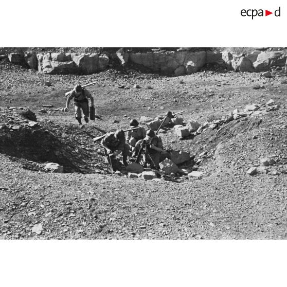 Des jeunes engagés militaires s'entraînent au tir avec un mortier en montagne.