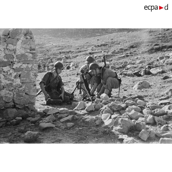 Des jeunes engagés militaires s'entraînent au tir avec un mortier en montagne.