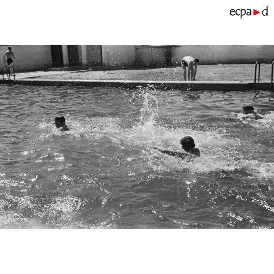 Des jeunes engagés militaires s'entraînent en natation, en plein air.