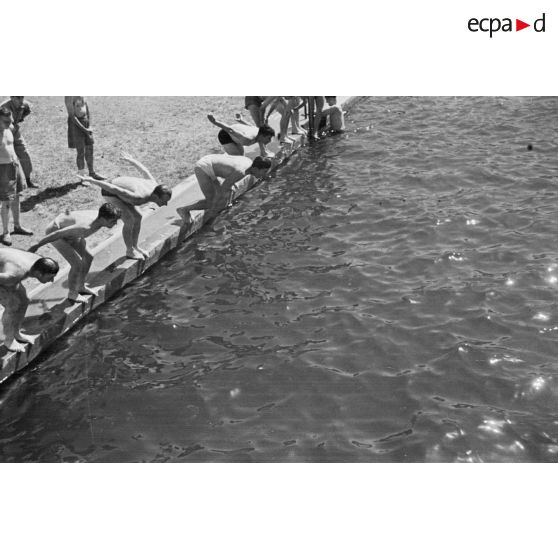 Des jeunes engagés militaires s'entraînent en natation, en plein air.