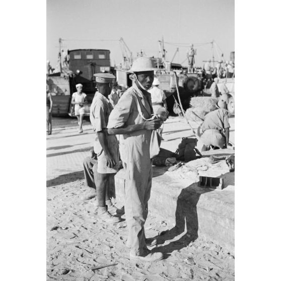 Dans le port de Marsa Matruh, le déchargement du ravitaillement de l'Axe par des prisonniers anglais et néo-zélandais.