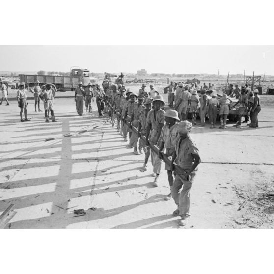 Dans le port de Marsa Matruh, le déchargement du ravitaillement de l'Axe par des prisonniers anglais et néo-zélandais.