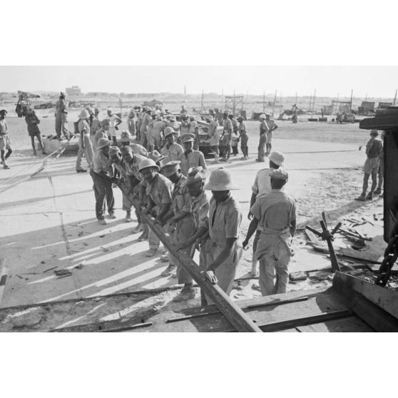 Dans le port de Marsa Matruh, le déchargement du ravitaillement de l'Axe par des prisonniers anglais et néo-zélandais.