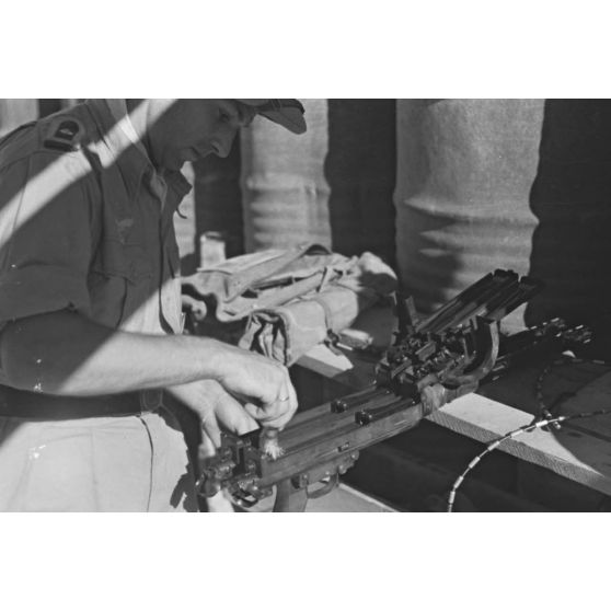 Sous l'aile d'un Stuka, un mécanicien effectue la maintenance d'une mitrailleuse MG-81 qui équipe les Junkers Ju-87 du Sturzkampfgechwader 3.