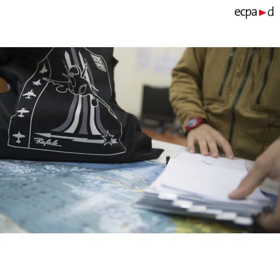 Dessin d'un avion Rafale sur le sac logotypé d'un pilote au briefing sur la base aérienne d'Al Dhafra (BA 104), aux Emirats arabes unis.